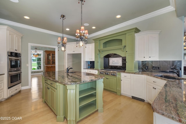 1704 Liam St, Carthage, MO 64836 - kitchen with double oven, green cabinets, a sink, a chandelier, and crown molding