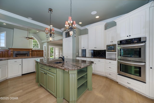 1704 Liam St, Carthage, MO 64836 - kitchen featuring green cabinets, appliances with stainless steel finishes, a sink, white cabinetry, and crown molding