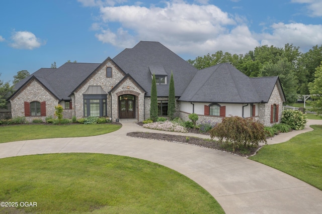 1704 Liam St, Carthage, MO 64836 - french country home with french doors, stone siding, a front yard, and roof with shingles