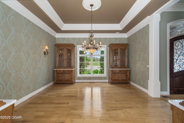 1704 Liam St, Carthage, MO 64836 - dining space with a chandelier, light wood-type flooring, crown molding, wallpapered walls, and a raised ceiling