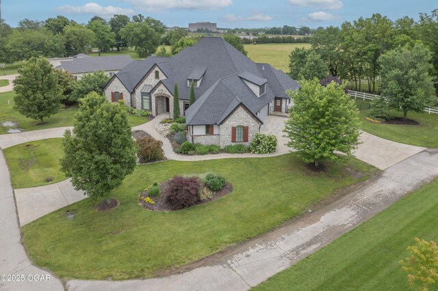 1704 Liam St, Carthage, MO 64836 - french country home featuring stone siding, driveway, and a front lawn