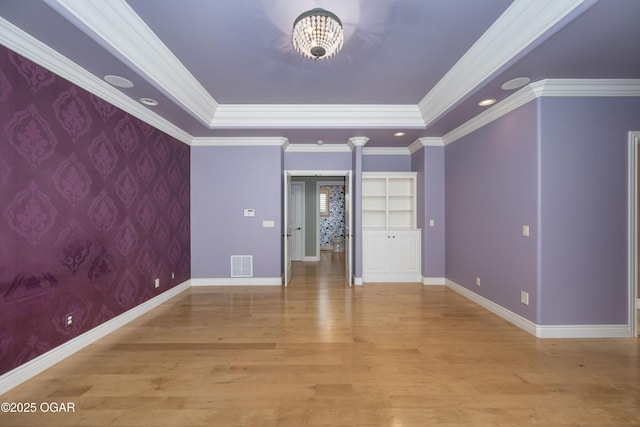 1704 Liam St, Carthage, MO 64836 - unfurnished room with ornate columns, baseboards, light wood-style floors, a raised ceiling, and ornamental molding