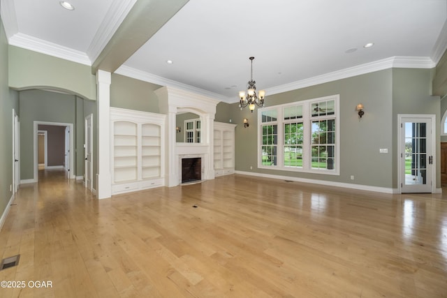 1704 Liam St, Carthage, MO 64836 - unfurnished living room with a chandelier, light wood-style floors, a fireplace with flush hearth, crown molding, and baseboards