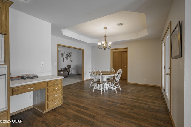 201 Canary Ln, Commerce, OK 74339 - dining area featuring a raised ceiling, a chandelier, dark wood-type flooring, and baseboards
