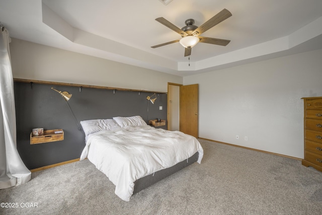 201 Canary Ln, Commerce, OK 74339 - bedroom featuring a tray ceiling, carpet floors, baseboards, and a ceiling fan