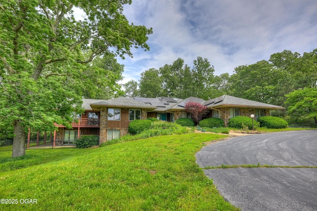 13495 Dogwood Rd, Carthage, MO 64836 - view of front of house with roof mounted solar panels, stone siding, and driveway