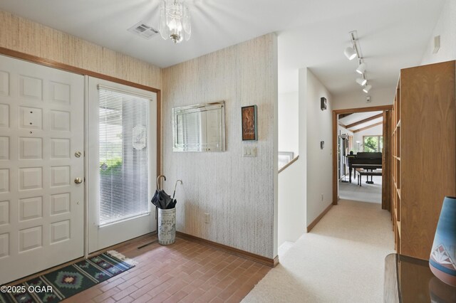 13495 Dogwood Rd, Carthage, MO 64836 - entrance foyer featuring baseboards, wallpapered walls, a chandelier, rail lighting, and brick patterned floors