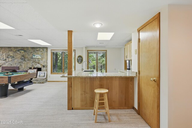 13495 Dogwood Rd, Carthage, MO 64836 - kitchen with light colored carpet, a sink, light stone countertops, and a peninsula