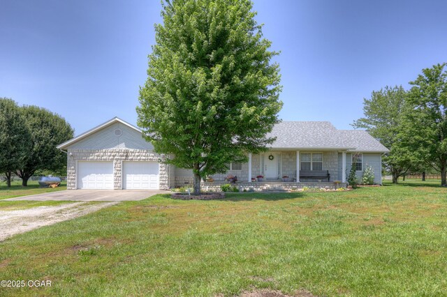 16050 Alford Ln, Diamond, MO 64840 - view of front facade with driveway, a front lawn, an attached garage, a porch, and stone siding