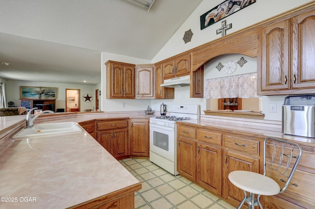 16050 Alford Ln, Diamond, MO 64840 - kitchen featuring white range with gas stovetop, under cabinet range hood, light countertops, brown cabinets, and lofted ceiling