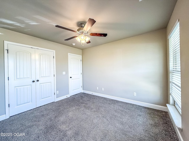 815 Delaney Dr, Carl Junction, MO 64834 - unfurnished bedroom with dark carpet, a closet, and a ceiling fan