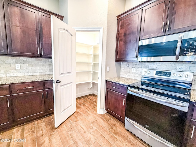 815 Delaney Dr, Carl Junction, MO 64834 - kitchen with appliances with stainless steel finishes, backsplash, light wood-style flooring, and dark brown cabinets