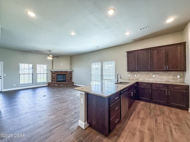815 Delaney Dr, Carl Junction, MO 64834 - kitchen featuring stainless steel dishwasher, dark wood-style flooring, dark brown cabinets, a brick fireplace, and recessed lighting