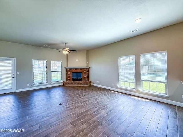 815 Delaney Dr, Carl Junction, MO 64834 - unfurnished living room featuring plenty of natural light, dark wood-style flooring, a ceiling fan, and a brick fireplace