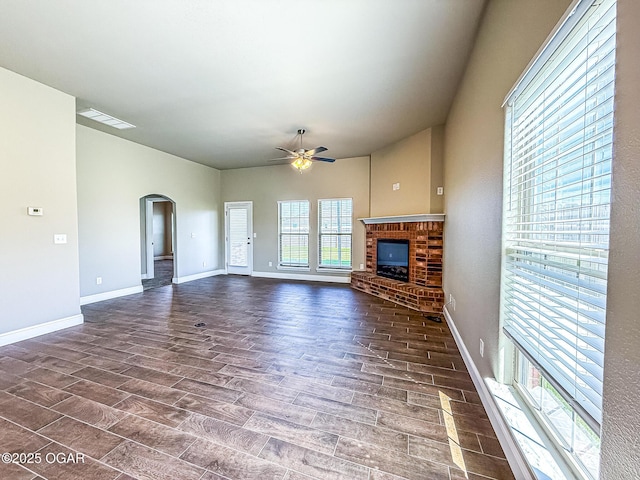 815 Delaney Dr, Carl Junction, MO 64834 - unfurnished living room with arched walkways, ceiling fan, a fireplace, and wood finished floors