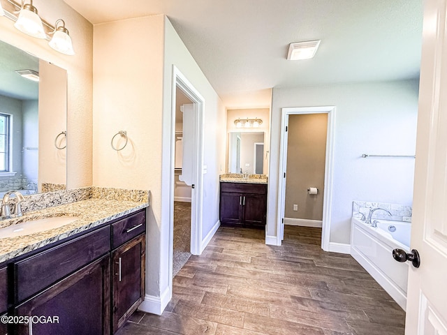 815 Delaney Dr, Carl Junction, MO 64834 - bathroom featuring wood finished floors, vanity, and a garden tub