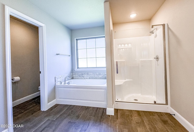 815 Delaney Dr, Carl Junction, MO 64834 - bathroom featuring wood finished floors, a garden tub, and a shower stall