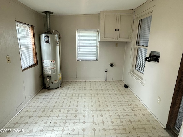 421 N Webb St, Webb City, MO 64870 - laundry room featuring gas water heater, light floors, and cabinet space