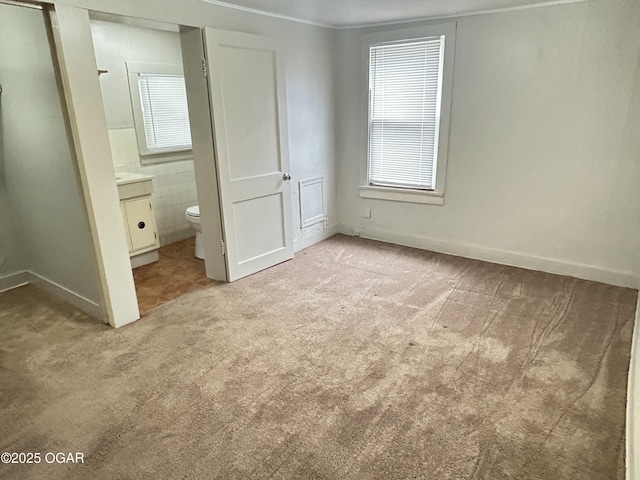 421 N Webb St, Webb City, MO 64870 - unfurnished bedroom with light colored carpet, ensuite bathroom, and baseboards