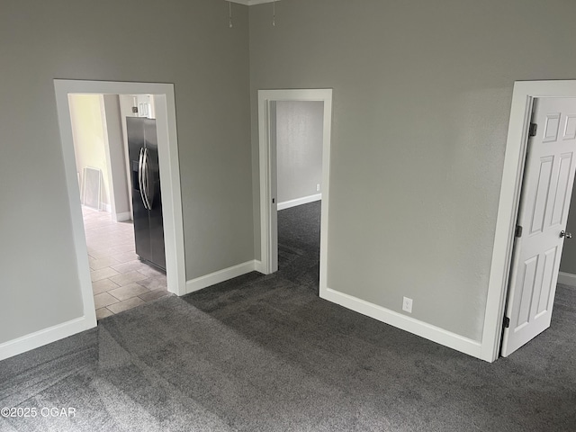 1816 S Connor Ave, Joplin, MO 64804 - unfurnished room with dark colored carpet, baseboards, attic access, and dark tile patterned floors
