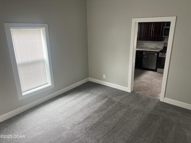 1816 S Connor Ave, Joplin, MO 64804 - spare room featuring baseboards, dark colored carpet, and plenty of natural light