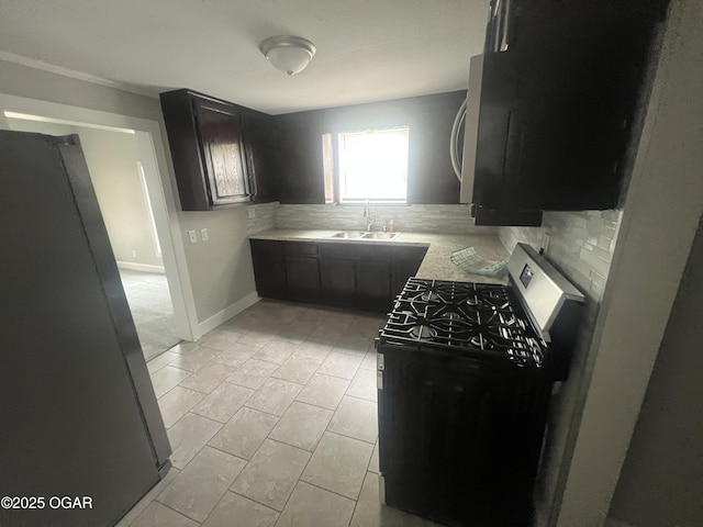 1816 S Connor Ave, Joplin, MO 64804 - kitchen featuring appliances with stainless steel finishes, a sink, tasteful backsplash, dark cabinetry, and light countertops
