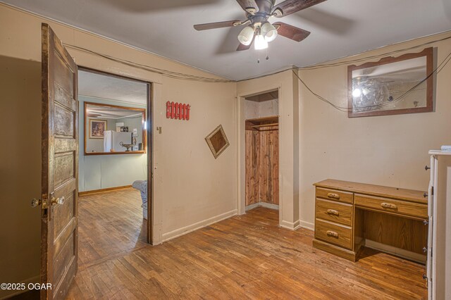 17279 Jackpine Rd, Carthage, MO 64836 - unfurnished bedroom featuring wood finished floors, freestanding refrigerator, baseboards, and a ceiling fan