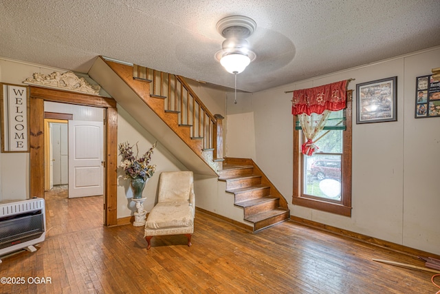 17279 Jackpine Rd, Carthage, MO 64836 - stairs featuring heating unit, hardwood / wood-style flooring, ceiling fan, and a textured ceiling