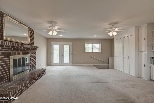 2521 Wisconsin Ave, Joplin, MO 64804 - unfurnished living room featuring ceiling fan, carpet floors, a brick fireplace, and french doors