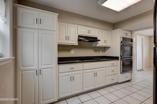 2521 Wisconsin Ave, Joplin, MO 64804 - kitchen featuring black appliances, under cabinet range hood, light tile patterned floors, white cabinets, and dark stone countertops