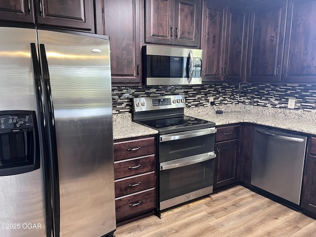 2038 W Trolley Car Ln, Carthage, MO 64836 - kitchen featuring appliances with stainless steel finishes, tasteful backsplash, light wood finished floors, and light stone countertops