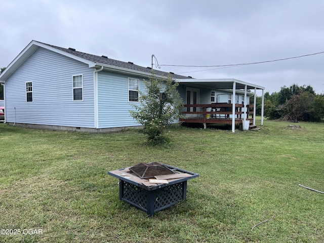 2038 W Trolley Car Ln, Carthage, MO 64836 - rear view of house featuring a fire pit, a yard, and a wooden deck