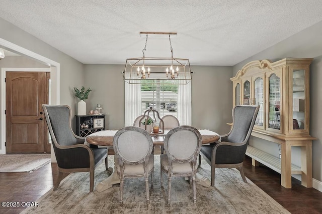 7870 County Lane 287, Carl Junction, MO 64834 - dining space featuring a chandelier, dark wood finished floors, and a textured ceiling