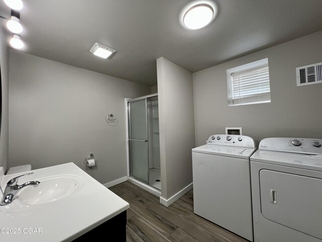 204 Webb St, Duenweg, MO 64841 - bathroom featuring washing machine and clothes dryer, a shower stall, wood finished floors, baseboards, and vanity