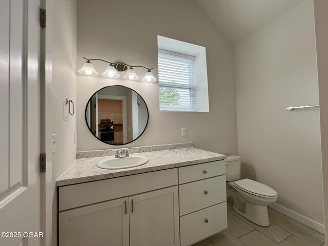204 Webb St, Duenweg, MO 64841 - bathroom with vanity, toilet, vaulted ceiling, tile patterned flooring, and baseboards