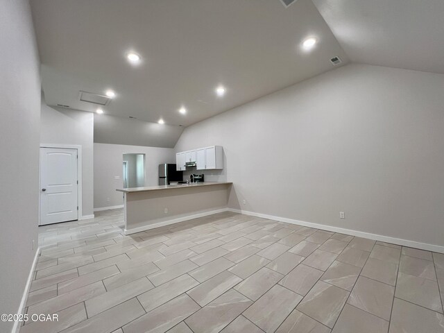 204 Webb St, Duenweg, MO 64841 - kitchen with lofted ceiling, freestanding refrigerator, white cabinets, a peninsula, and open floor plan