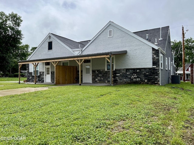 204 Webb St, Duenweg, MO 64841 - view of front of home featuring cooling unit, a front yard, a shingled roof, stone siding, and brick siding