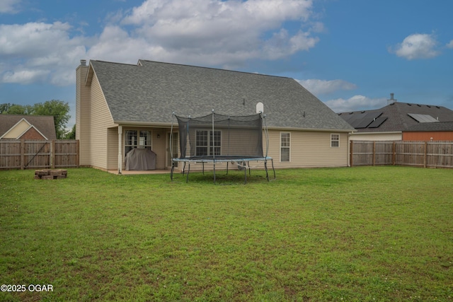 330 Sadie Ln, Webb City, MO 64870 - back of house with a trampoline, a chimney, and a shingled roof
