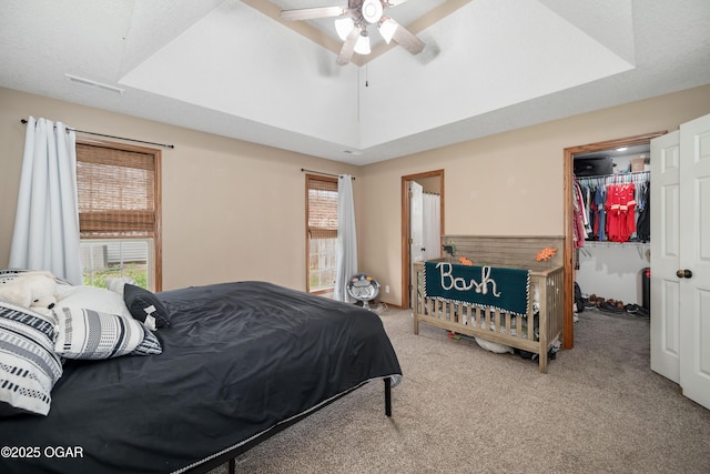 330 Sadie Ln, Webb City, MO 64870 - carpeted bedroom with a walk in closet, a closet, a tray ceiling, and a ceiling fan