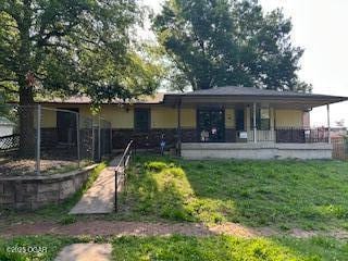 105 N Pearl Ave, Joplin, MO 64801 - rear view of house with covered porch and a yard