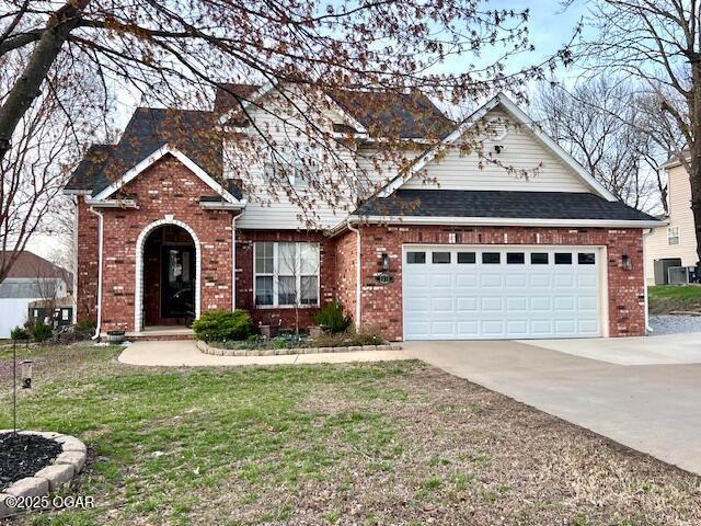 3331 Willow Ln, Joplin, MO 64801 - traditional-style house featuring driveway, brick siding, a front yard, and an attached garage