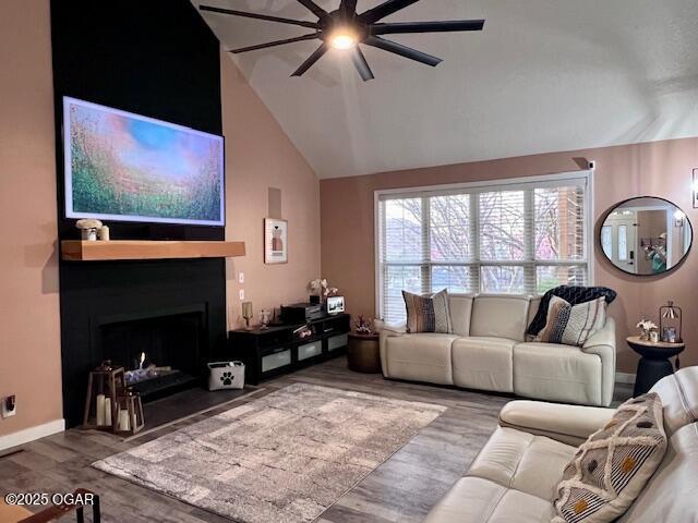 3331 Willow Ln, Joplin, MO 64801 - living area featuring ceiling fan, lofted ceiling, a large fireplace, wood finished floors, and baseboards