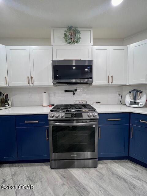 3331 Willow Ln, Joplin, MO 64801 - kitchen with stainless steel appliances, blue cabinets, light countertops, and white cabinetry