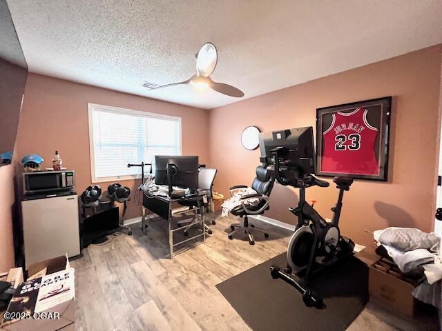 3331 Willow Ln, Joplin, MO 64801 - workout area featuring ceiling fan, wood finished floors, a textured ceiling, and baseboards