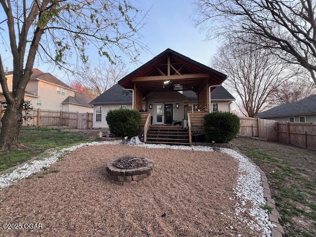 3331 Willow Ln, Joplin, MO 64801 - rear view of house with a fenced backyard and an outdoor fire pit
