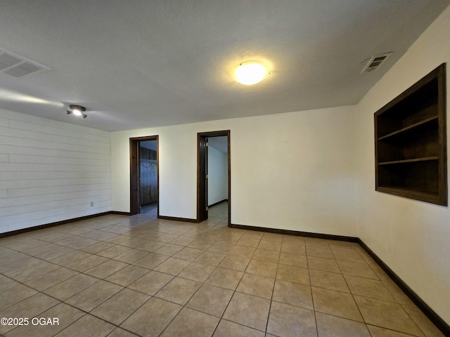615 N Van Hoorebeke Rd, Joplin, MO 64801 - unfurnished room featuring built in shelves, baseboards, and light tile patterned floors
