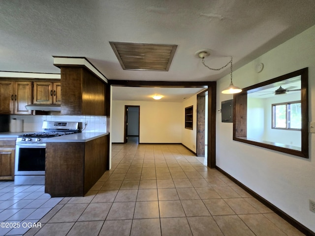 615 N Van Hoorebeke Rd, Joplin, MO 64801 - kitchen with gas range, under cabinet range hood, decorative backsplash, baseboards, and light tile patterned flooring