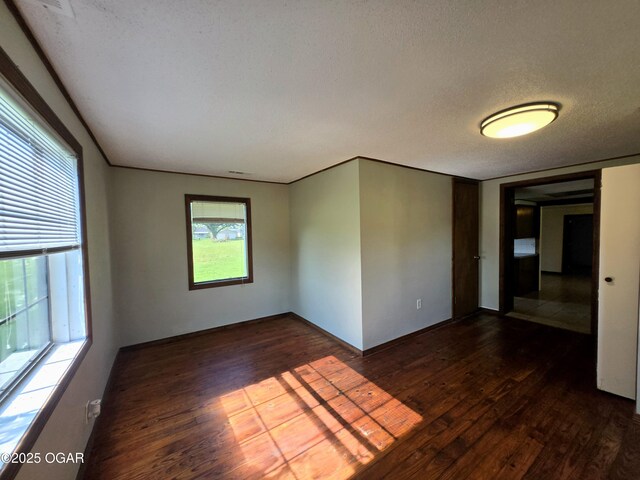 615 N Van Hoorebeke Rd, Joplin, MO 64801 - empty room with dark wood finished floors and a textured ceiling