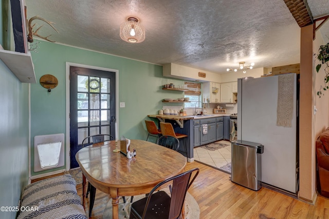509 Brentwood Dr, Carl Junction, MO 64834 - dining area with a textured ceiling, plenty of natural light, heating unit, and light wood-style floors