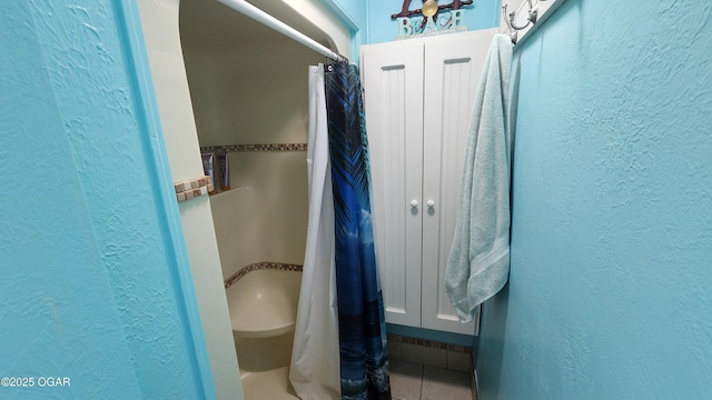 3002 S Main St, Galena, KS 66739 - bathroom featuring a textured wall, a shower with shower curtain, and tile patterned flooring